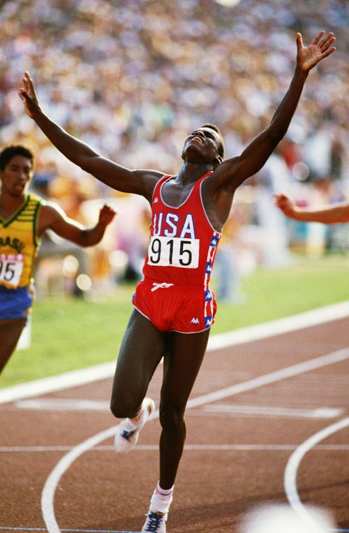 Carl Lewis raises his arms in celebration