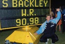 Steve Backley poses by the scoreboard after setting a new world record