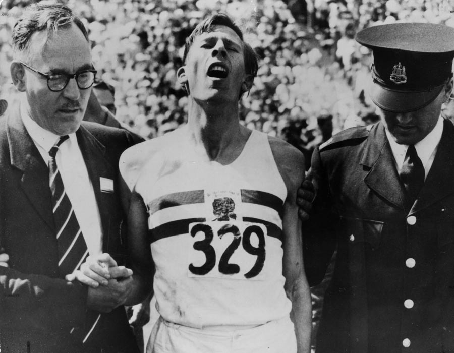George Truelove and a police officer help Roger Bannister after 'The Mile Of The Century'