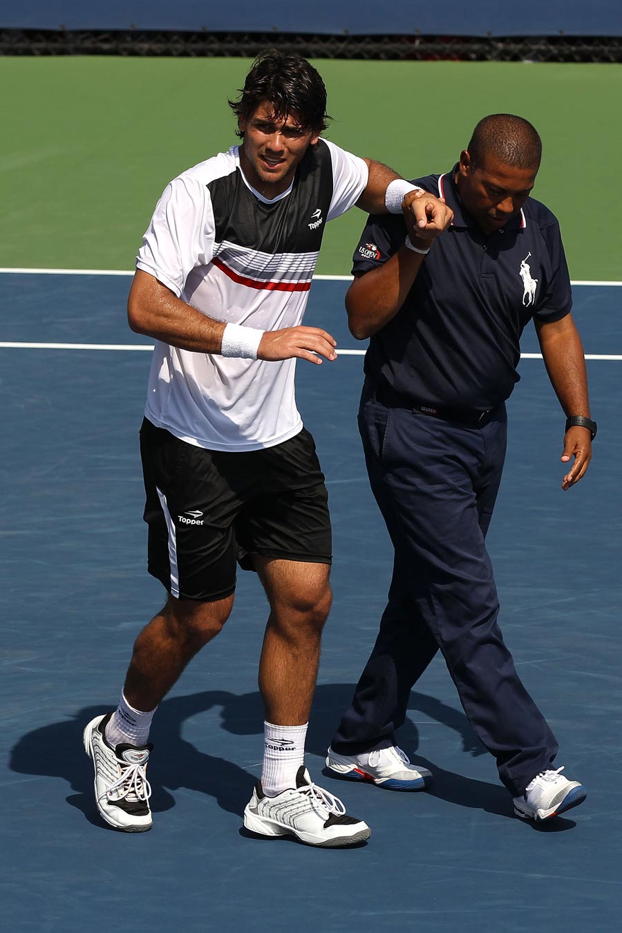 Eduardo Schwank is helped off the court with an injury