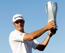 Dustin Johnson shows off his trophy