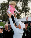 Ben Crane lifts his daughter into the air after winning the Farmers Insurance Open