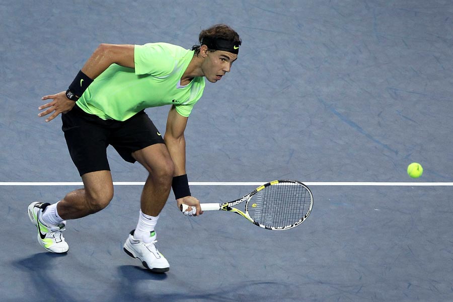 Rafael Nadal stoops to meet a return