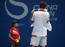 A ball girl looks up at Michael Berrer