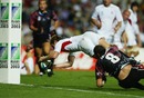 Will Greenwood dives over to score a try despite the tackle of George Chkhaidze