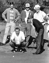 Arnold Palmer looks on as Gardner Dickinson makes a putt