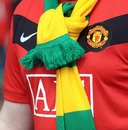 A Manchester United supporter wears a green and gold scarf