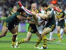Sam Tomkins is tackled by three Australian players