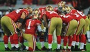 The 49ers huddle before the game begins