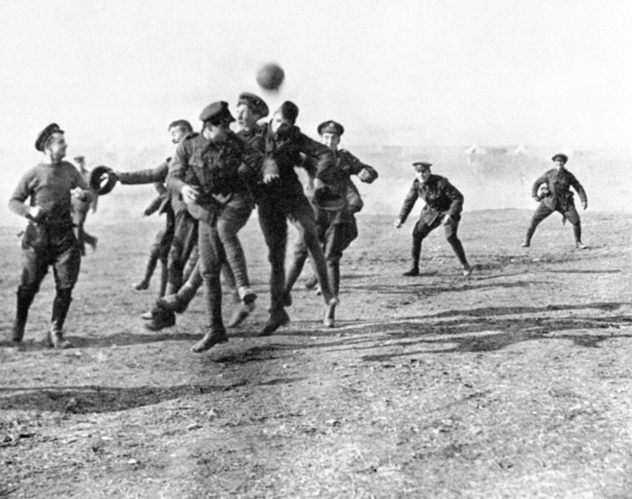 Soldiers playing football on the beach