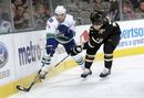 Keith Ballard of the Vancouver Canucks tries to keep the puck away from James Neal of the Dallas Stars