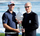 Dustin Johnson takes the AT&T Pebble Beach Pro-Am trophy from actor Clint Eastwood