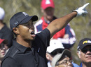 Tiger Woods shouts out a warning after firing a drive off line