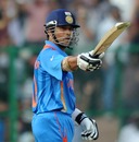Sachin Tendulkar raises his bat after reaching 50 runs