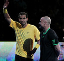 Pete Sampras salutes the crowd as Andre Agassi looks on