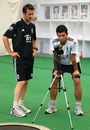 Jade Dernbach and bowling coach Kevin Shine review a video of Dernbach's bowling