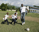 Usain Bolt plays football with some local schoolchildren