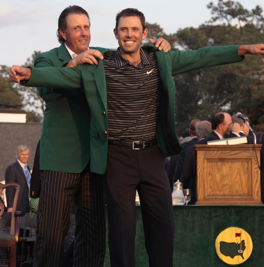 Phil Mickelson helps Charl Schwartzel with his Green Jacket