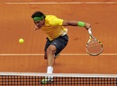 Rafael Nadal stoops to reach the ball against Gael Monfils