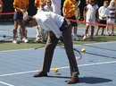 President Barack Obama hits a tennis ball between his legs