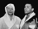 A beaten but unbowed Henry Cooper poses with Muhammad Ali