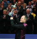 John Higgins shows off his trophy