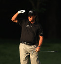 Phil Mickelson shades his eyes to follow his ball