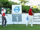 Graeme McDowell watches his tee-shot on the first hole as Rory McIlroy looks on