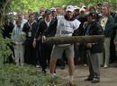 Luke Donald's caddie removes a old piece of tree trunk