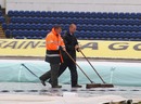 Groundstaff sweep standing water from the covers