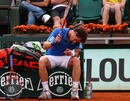 A dejected Andy Murray hits his racket against the clay