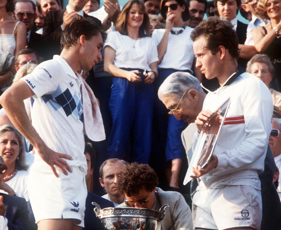 John McEnroe holds the silver plate as Ivan Lendl waits to receive the cup