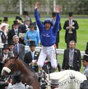 Frankie Dettori performs a flying dismount after Rewilding's win 