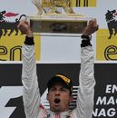 Jenson Button holds his trophy aloft