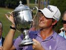 Webb Simpson holds the trophy 