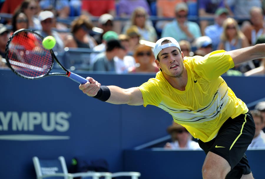 John Isner stretches for a volley