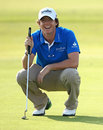 Rory McIlroy smiles as he lines up a putt