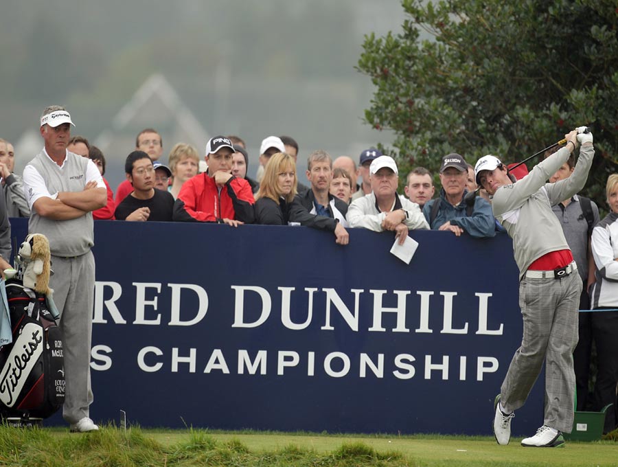 Rory McIlroy drives off the third tee watched by fellow countryman Darren Clarke