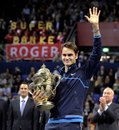 Roger Federer cradles his trophy