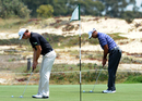 Dustin Johnson and Tiger Woods putt