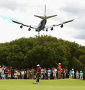 Tiger Woods waits to putt as a plane flies overhead