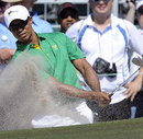 Tiger Woods splashes out of a bunker