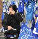 An Everton fan wipes away tears after looking at tributes to Gary Speed