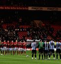 The players stand in the centre circle for a one minutes' applause in memory of Gary Speed