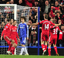 Liverpool players celebrate as David Luiz trudges away