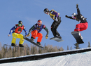 Competitors descend the course in the quarter-finals of the team snowboardcross