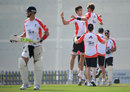 Steven Finn and Stuart Broad celebrate the dismissal of Kevin Pietersen during a training session