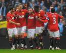 Wayne Rooney gets congratulated by his team-mates after scoring