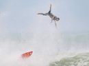 A surfer is thrown from his board as he catches a wave