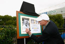 Rod Laver signs a picture marking the 50th anniversary of his first grand slam